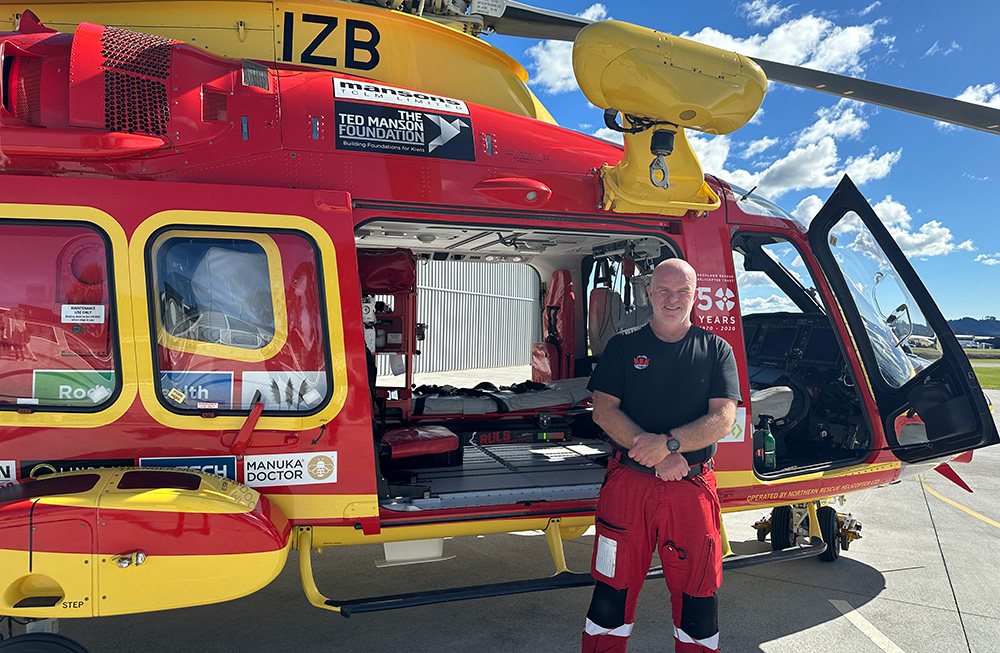 Mark standing in front of a helicopter