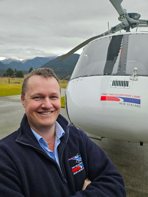 Brad standing in front of a helicopter