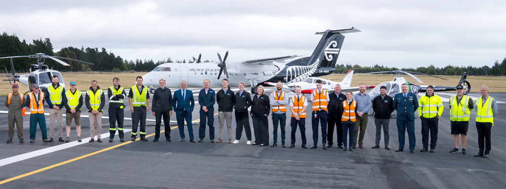 CAA and industry reps standing in a line in front of various aircraft